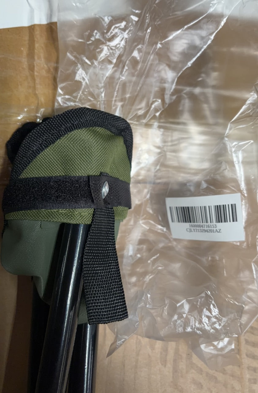 Green folding stool storage bag with straps over folded tripod legs