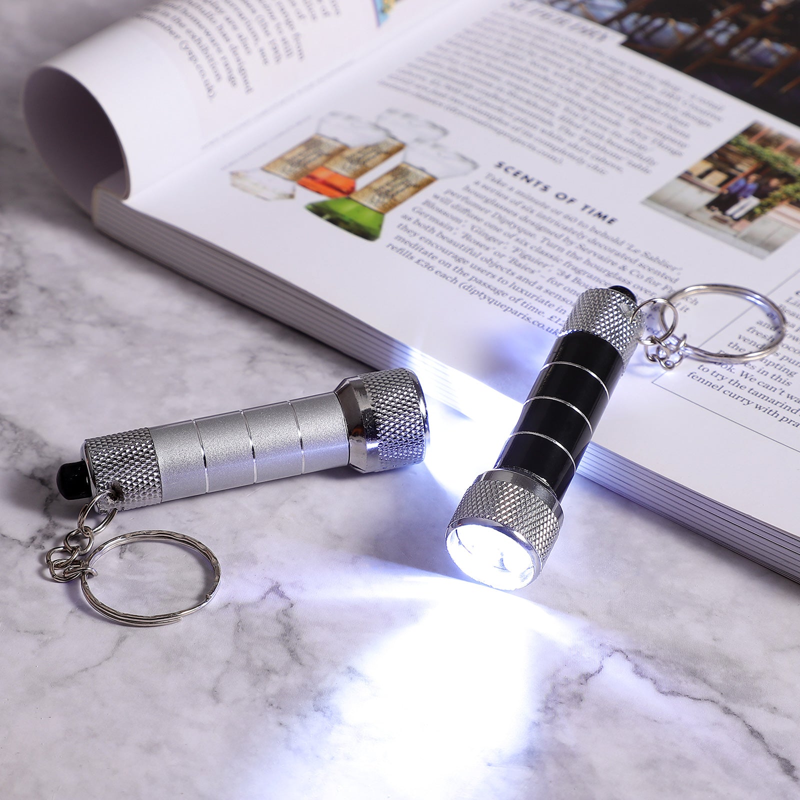 Mini aluminum LED keychain flashlight with black handle, silver body, round keyring