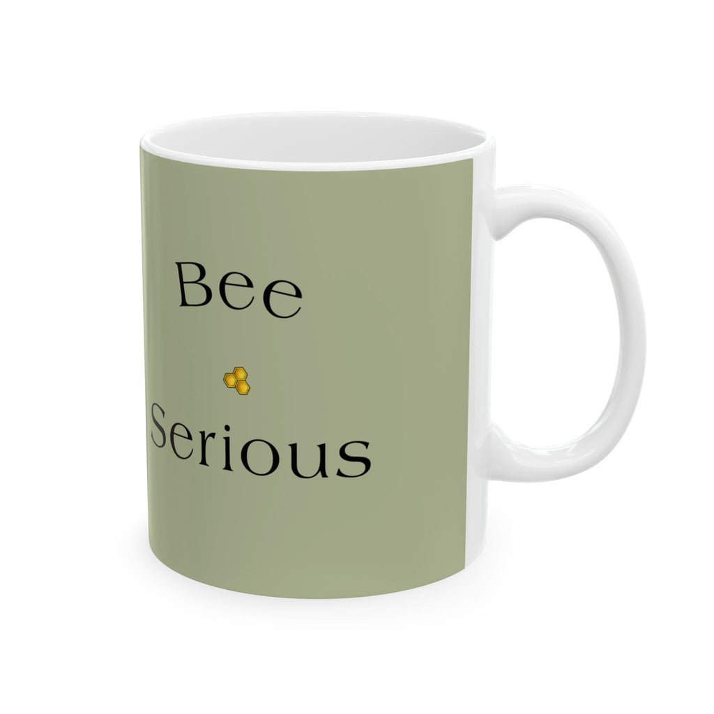 Olive green mug with 'Bee Serious' text in black and a small yellow flower icon