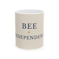 Beige ceramic mug with blue 'BEE INDEPENDENT' text and small bee emblem