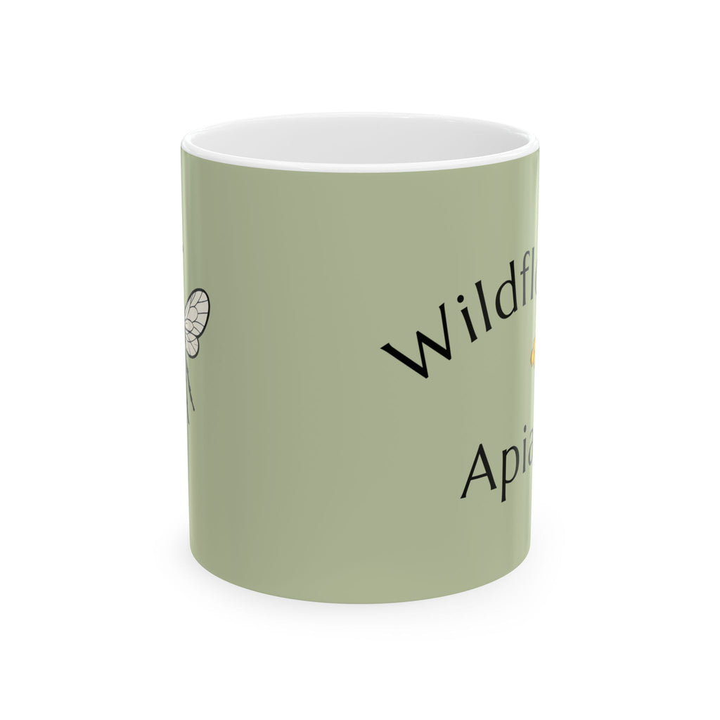 Green ceramic mug with black script text reading “Wildf…” and “Apiary”