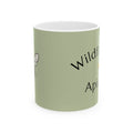 Green ceramic mug with black script text reading “Wildf…” and “Apiary”