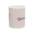 Pink ceramic coffee cup with partial 'Queen' script and bee line art
