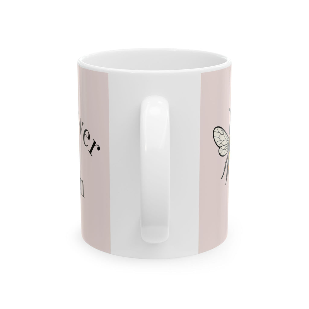 Pink ceramic coffee cup with vertical white panel and partial bee decal
