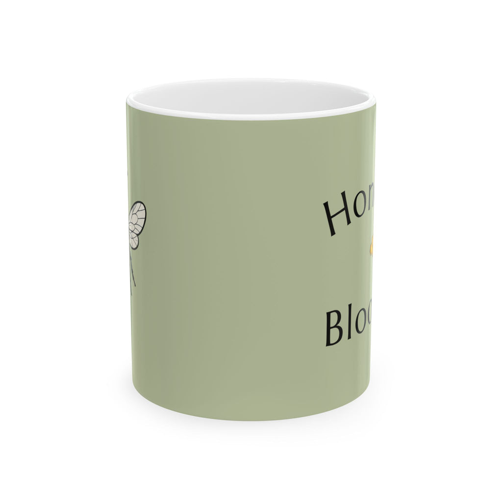 Olive green mug with bee illustration and partial Honey Bloom text