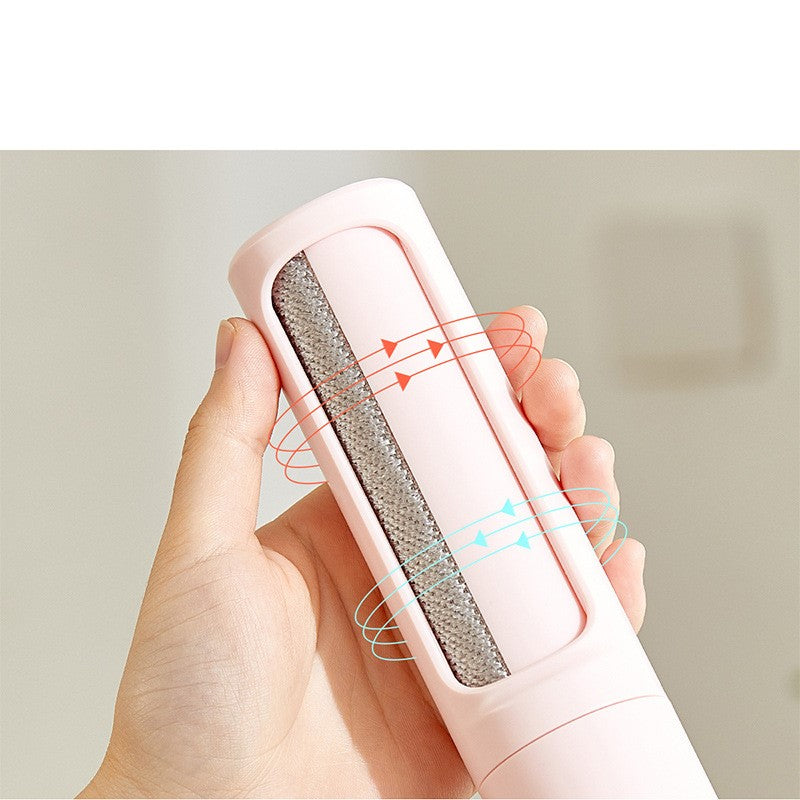 Pink pet hair remover brush held to fabric with lint-removal window