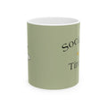 Light green ceramic mug with black 'Social...' and 'Tired' text, white rim.