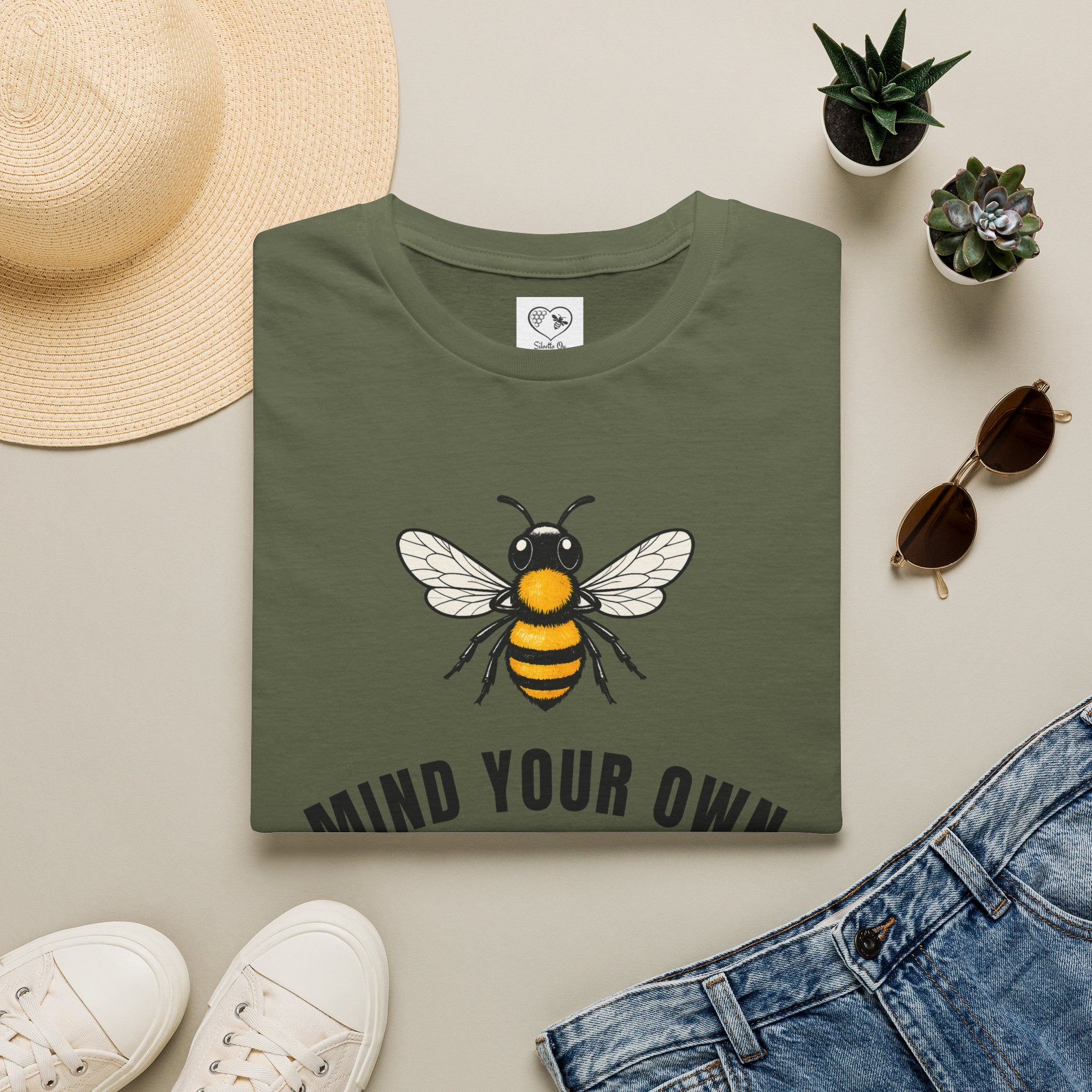 Military green t-shirt with bee illustration and bold "MIND YOUR OWN" text on front