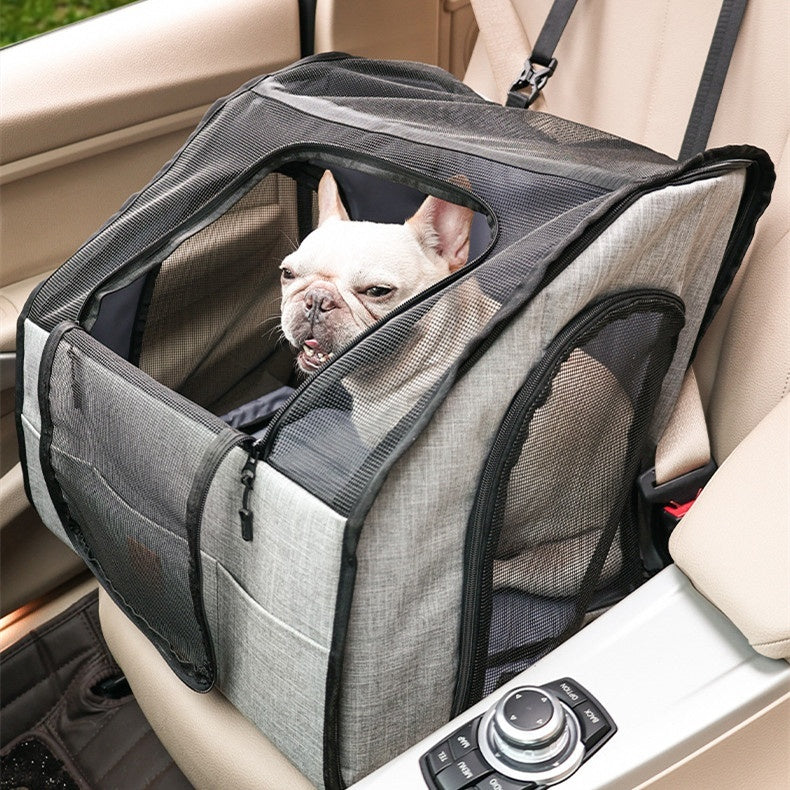 Gray pet car crate with mesh sides and a dog inside on a vehicle seat