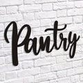 Metal pantry wall sign with cursive “Pantry” in black on white brick