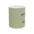 Green mug with white rim and partial honey herbs text print