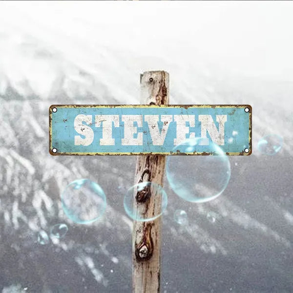 Vintage aluminum name plate sign reading STEVEN on a weathered wooden post.