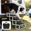 Foldable dog ramp with black non-slip steps beside SUV door, white dog climbing up