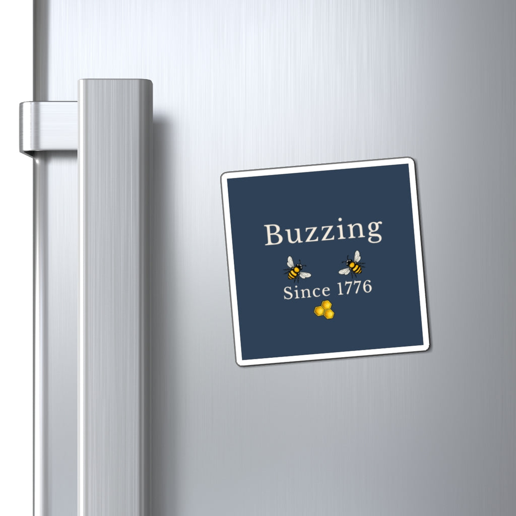 Bee refrigerator magnet on stainless steel fridge with blue "Buzzing Since 1776" square