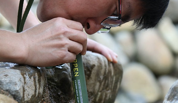 Blue filter straw being used outdoors with mouthpiece end
