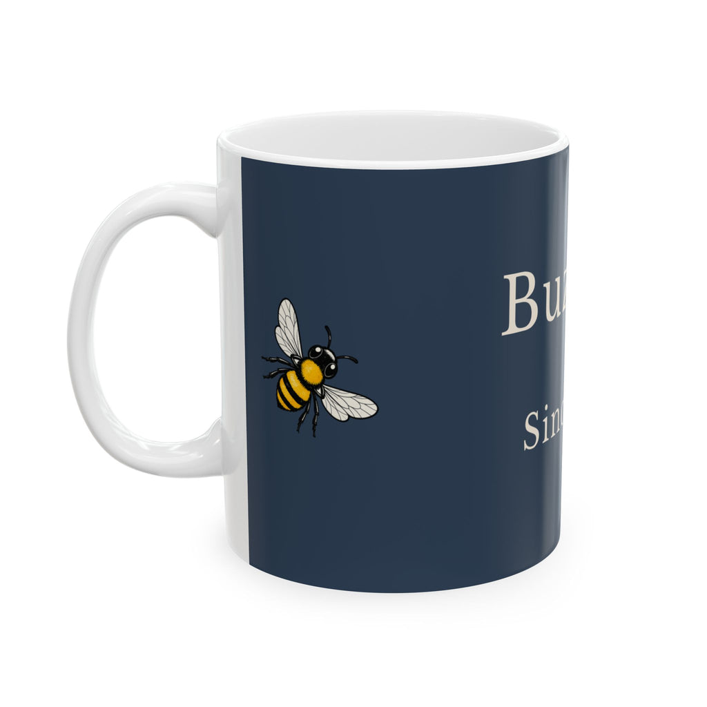 Navy ceramic mug with bee graphic and partial 'Buzzing' text