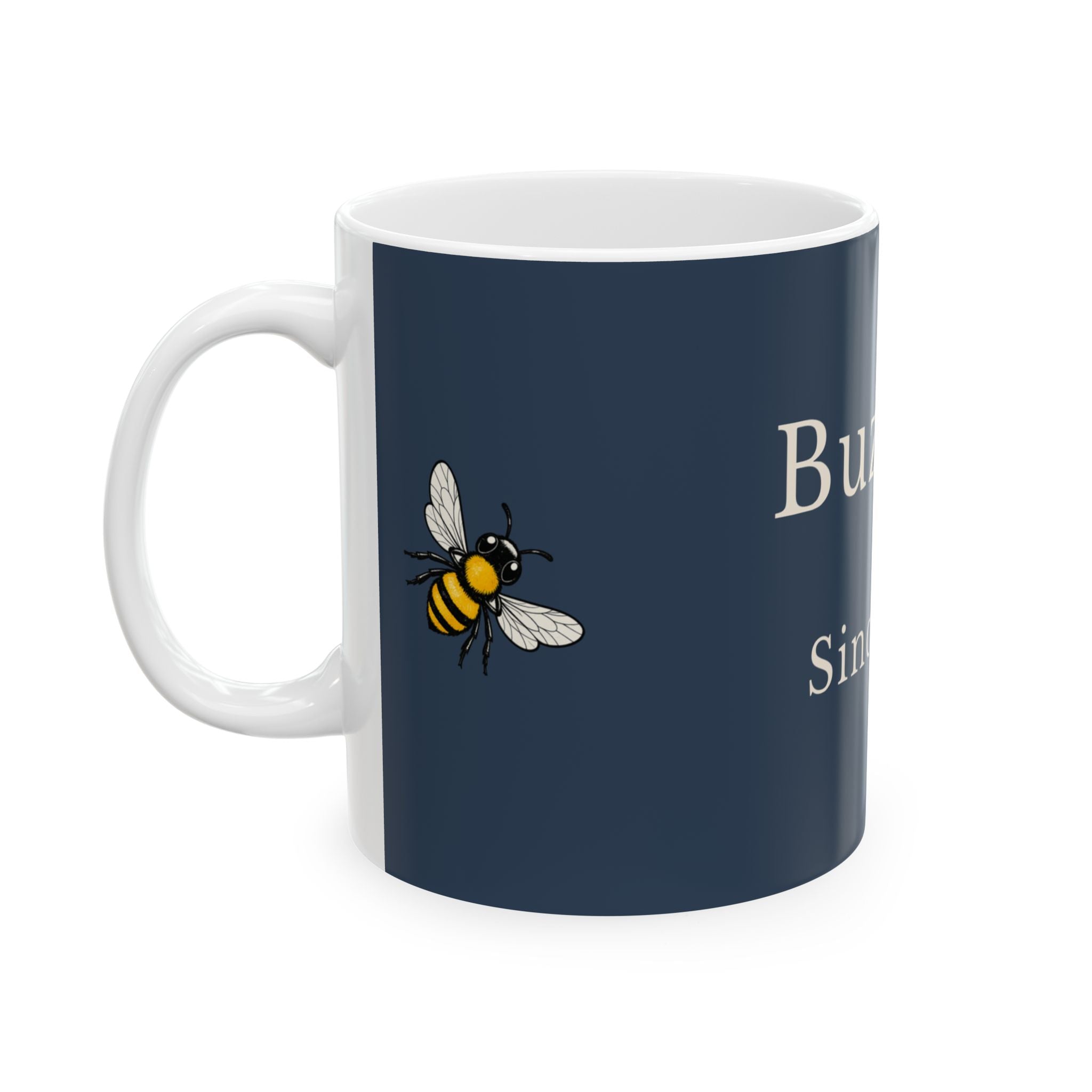 Navy ceramic mug with bee graphic and partial 'Buzzing' text