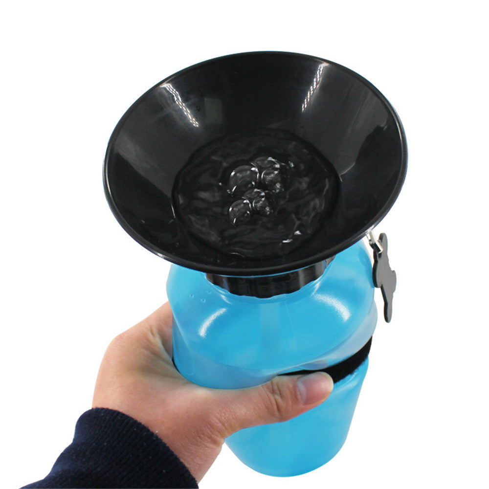 Blue portable pet water bottle with attached black bowl held in hand.