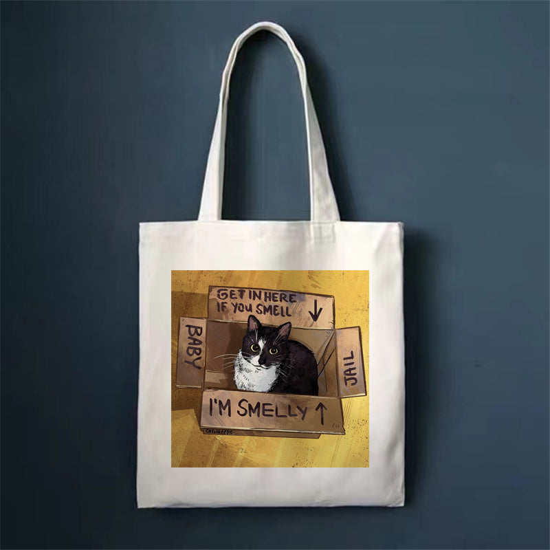 Canvas tote bag with cat behind taped signs illustration, square front print and long handles