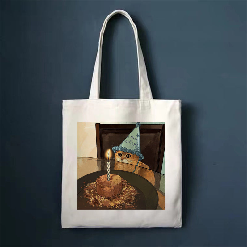 Canvas tote bag, white, with orange cat portrait print.
