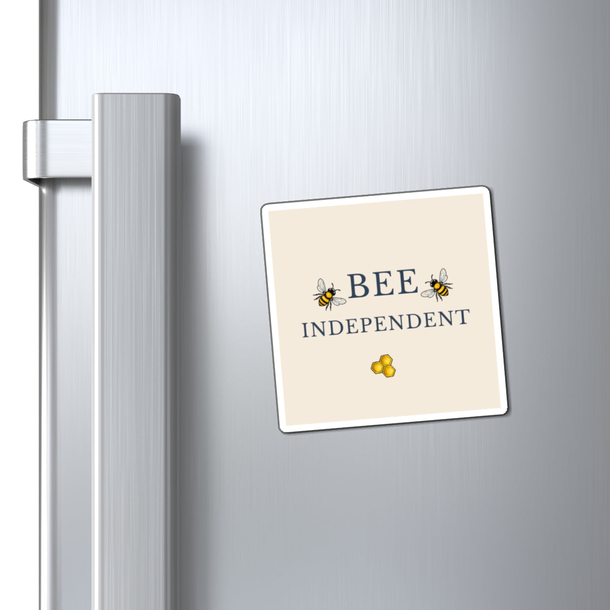 Bee-themed refrigerator magnet attached to metal fridge, showing 'BEE INDEPENDENT'