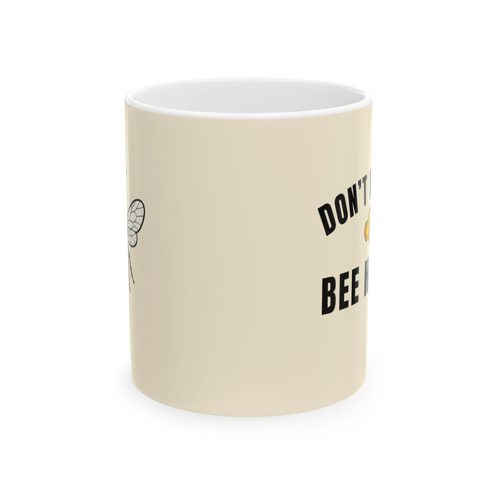 Beige ceramic mug with black text reading “DON’T” and “BEE”