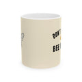 Beige ceramic mug with black text reading “DON’T” and “BEE”