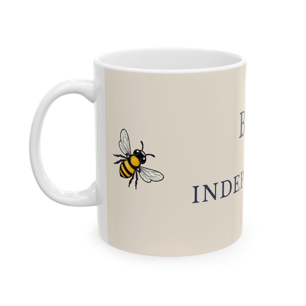 Beige ceramic mug with bee illustration, partial 'INDE' lettering, and white handle