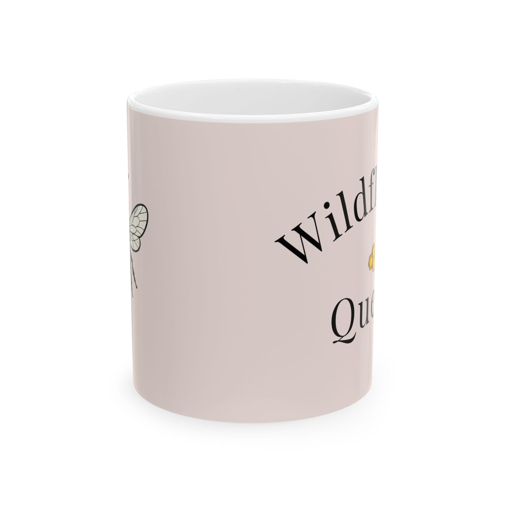 Pink ceramic coffee cup with partial Wildflower Queen text and bee graphic