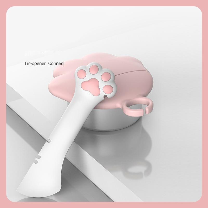 Pet food can spoon and lid opener with paw-shaped handle inserted into can lid