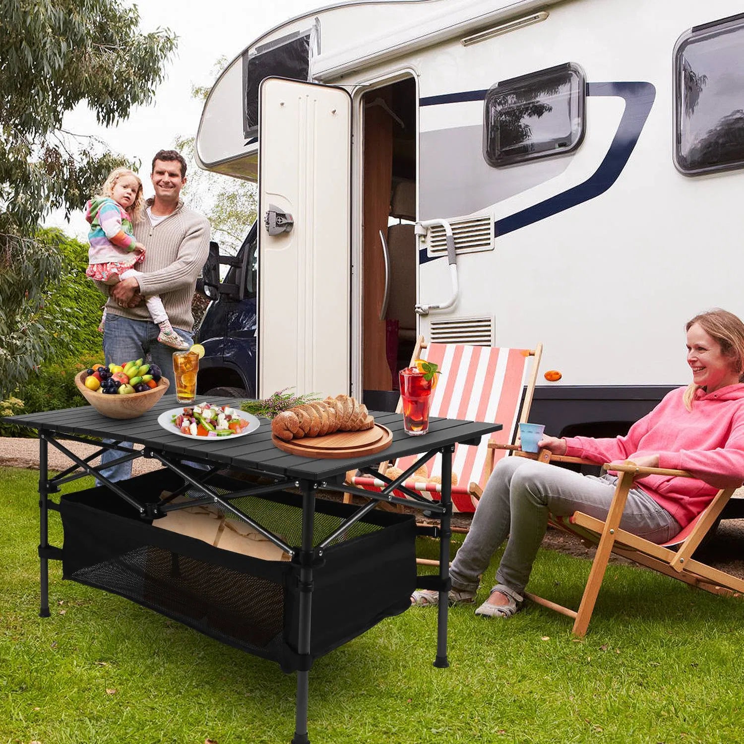 Black folding camping table with roll-up top, mesh basket, and drinks on the surface