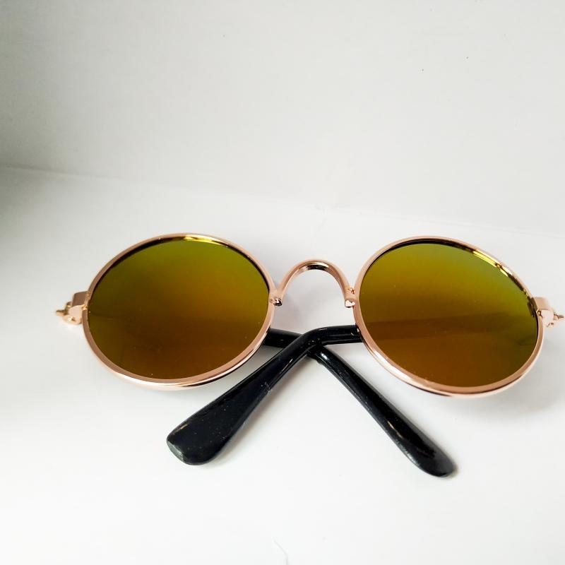 Round pet sunglasses with gold frame, olive-yellow lenses, and black side arms