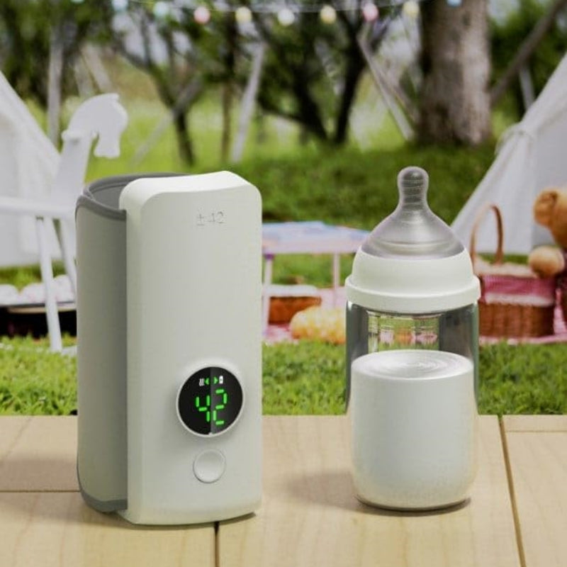 Baby bottle warmer with digital display and included bottle, shown on a countertop outdoors