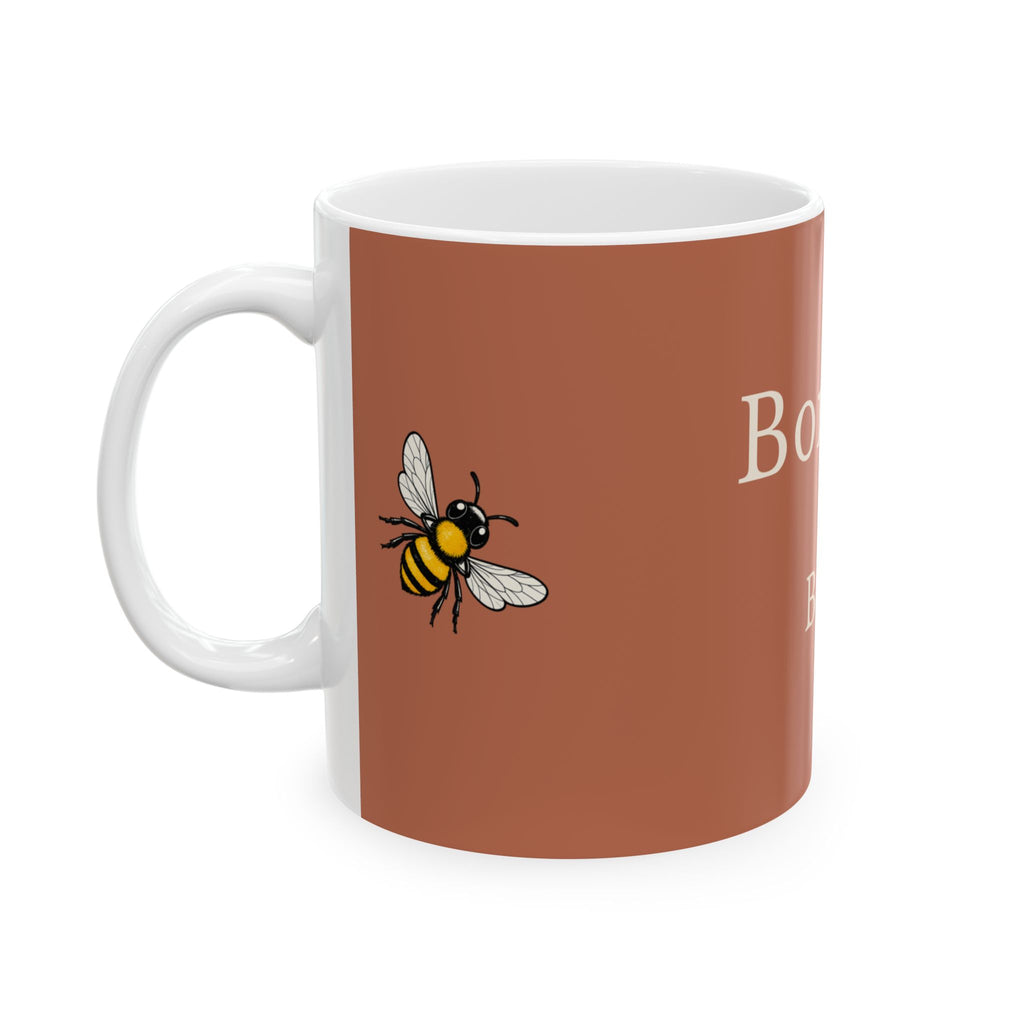 Brown mug with white interior and a bee graphic on the front