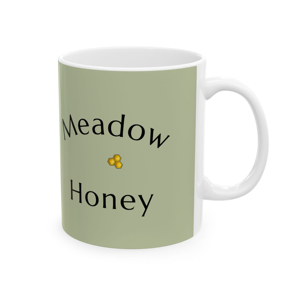 Olive green ceramic mug with “Meadow Honey” text and small yellow flower accent