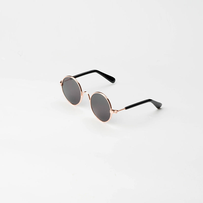 Round pet sunglasses with rose-gold frame, gray tinted lenses, and black side arms