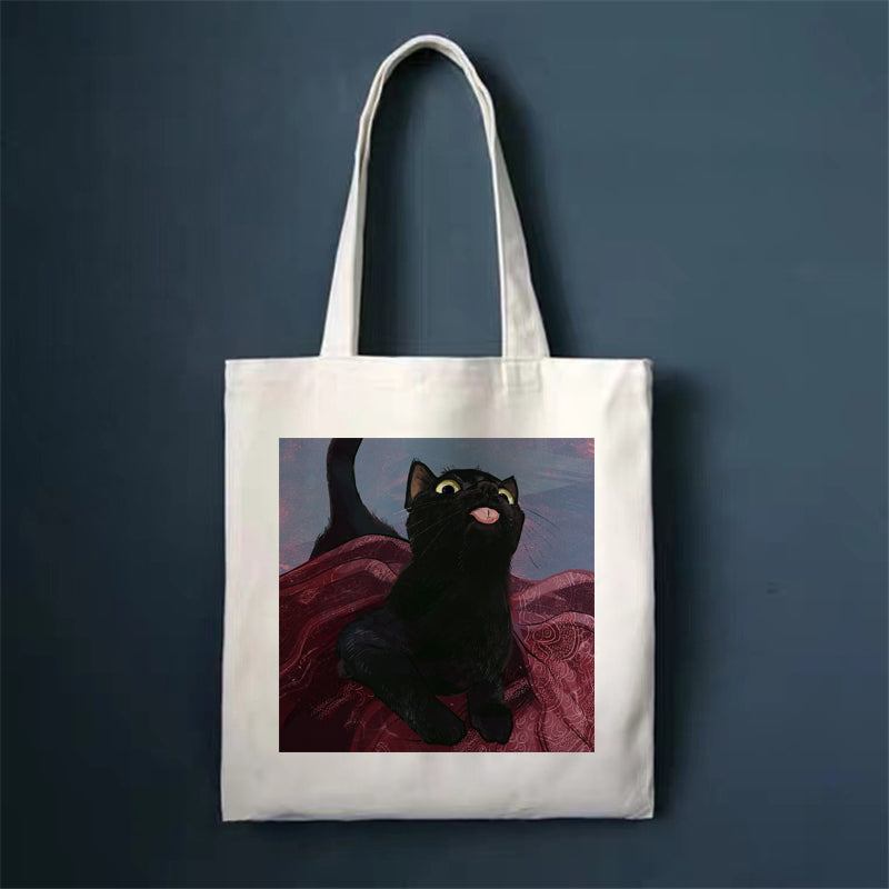 Canvas tote bag, white, with black cat on red patterned blanket print.