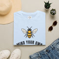 Light blue t-shirt with bee illustration and bold "MIND YOUR OWN" text on front