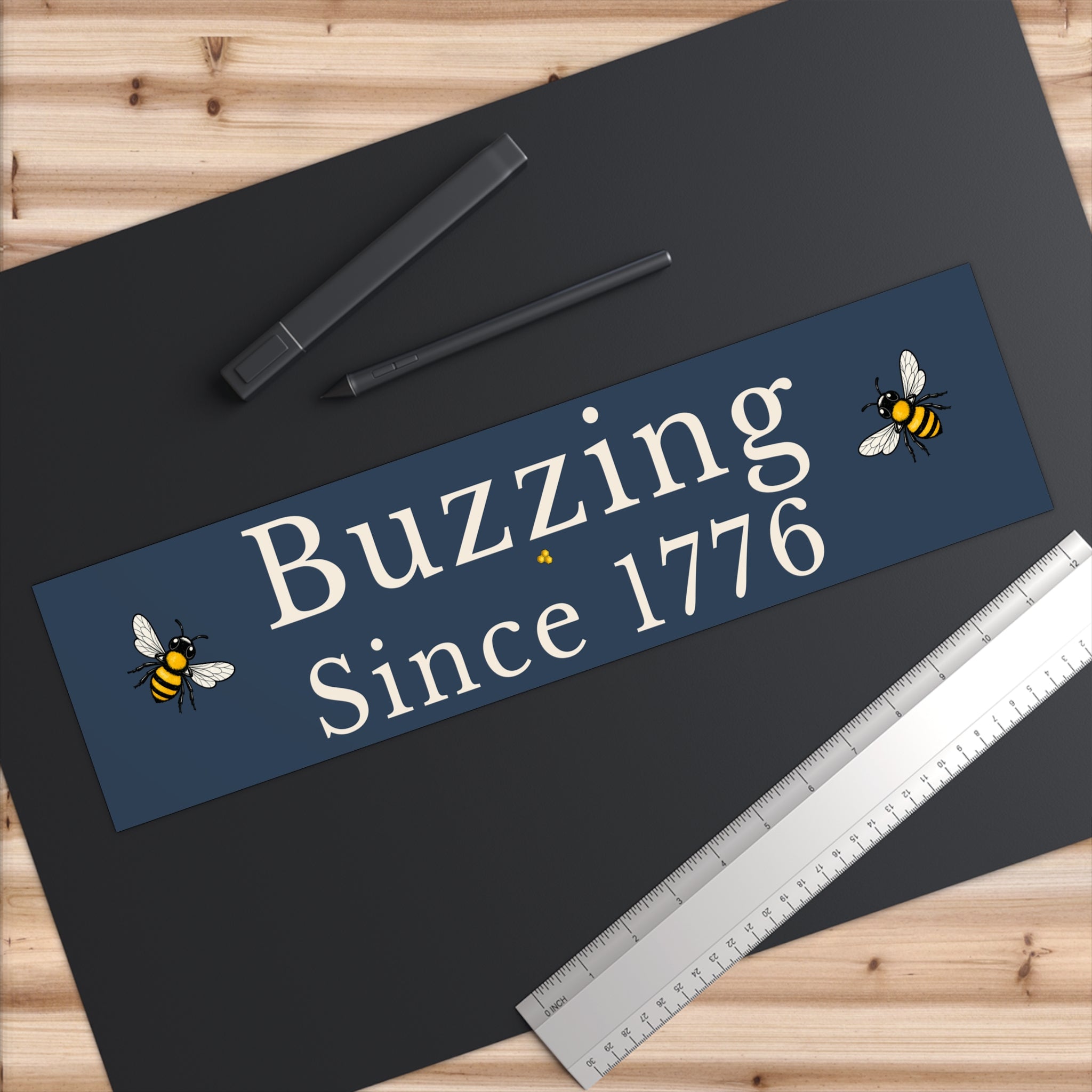 Angled rectangle bumper sticker with 'Buzzing Since 1776' and bee icons