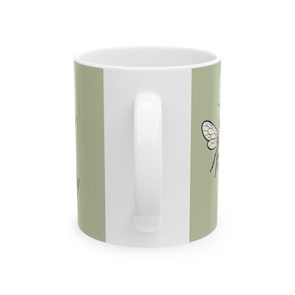 Green ceramic mug with white interior and small bee outline on side.