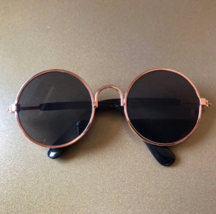Round sunglasses for pets with black lenses and gold-tone frames