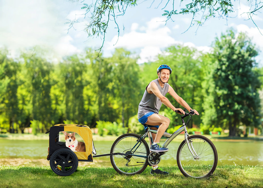 Yellow foldable dog bike trailer attached to a bicycle with mesh sides