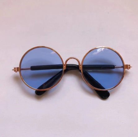Round sunglasses for pets with blue-tinted lenses and gold-tone frames