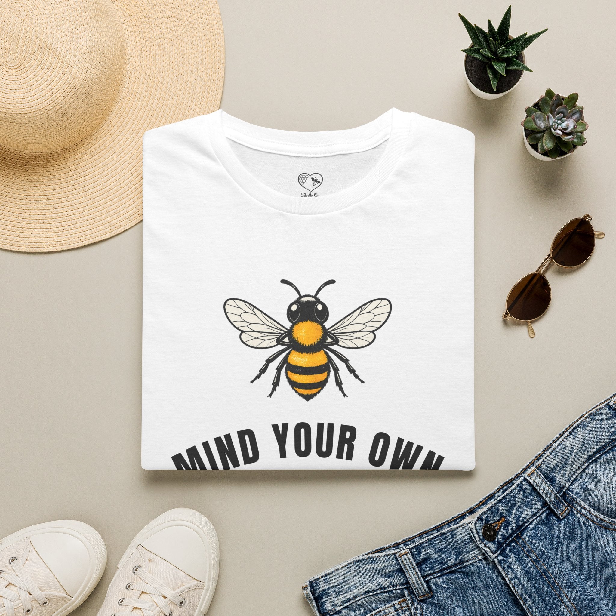 White t-shirt with bee illustration and bold "MIND YOUR OWN" text on front