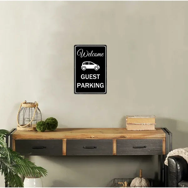 Metal tin sign with 'Welcome Guest Parking' design mounted on a wall above a wooden console