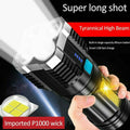 Black tactical flashlight with high beam and side COB lamp, held in a hand