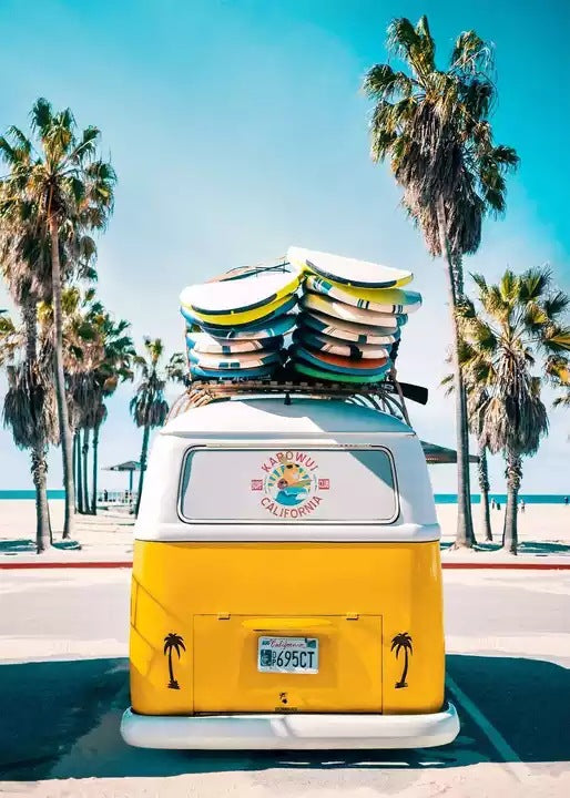 Yellow camper van canvas print with stacked surfboard decks and tall palm trees