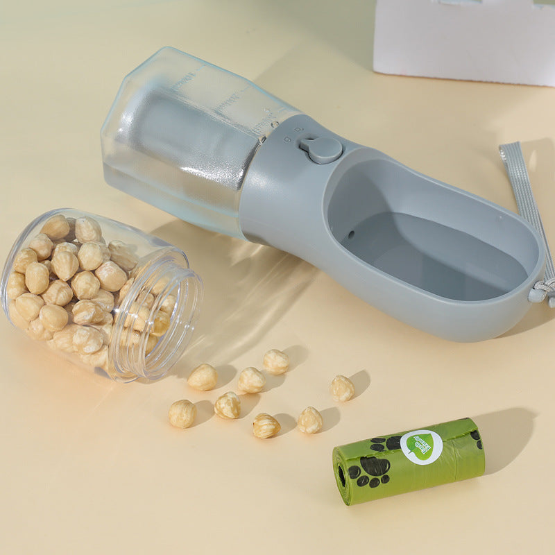 Portable pet travel cup with clear bottle, treat cup, and waste bag roll accessory