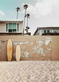 Canvas print of stucco wall with three surfboards and palm trees in the background