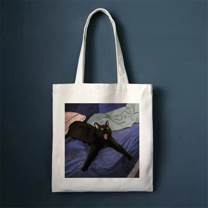 Canvas tote bag with black cat lying down illustration, square front print and long handles